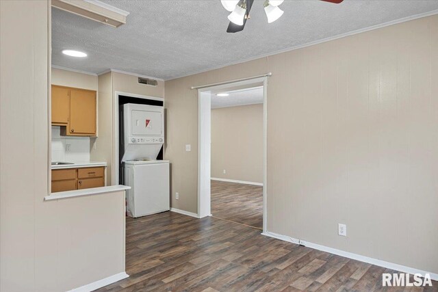 kitchen featuring ceiling fan, stacked washer / dryer, dark hardwood / wood-style flooring, and a textured ceiling