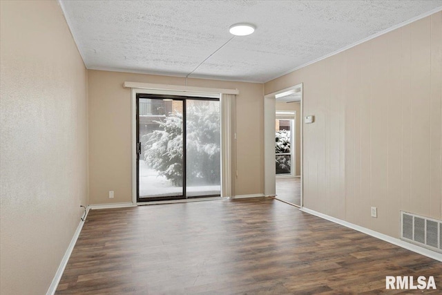 spare room with dark hardwood / wood-style flooring, crown molding, and a textured ceiling