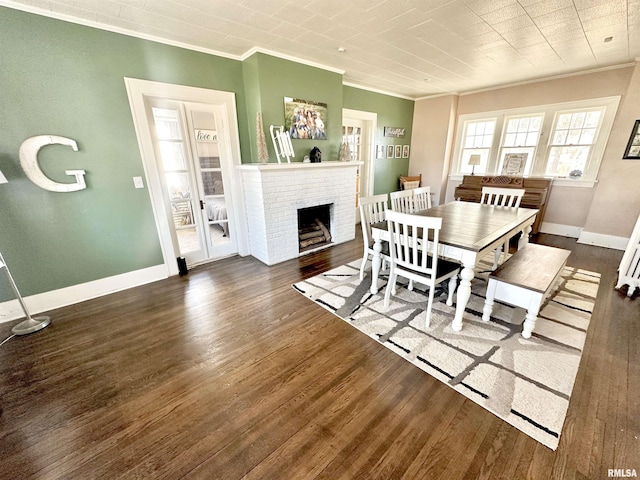 dining area featuring a fireplace, dark wood-type flooring, and crown molding