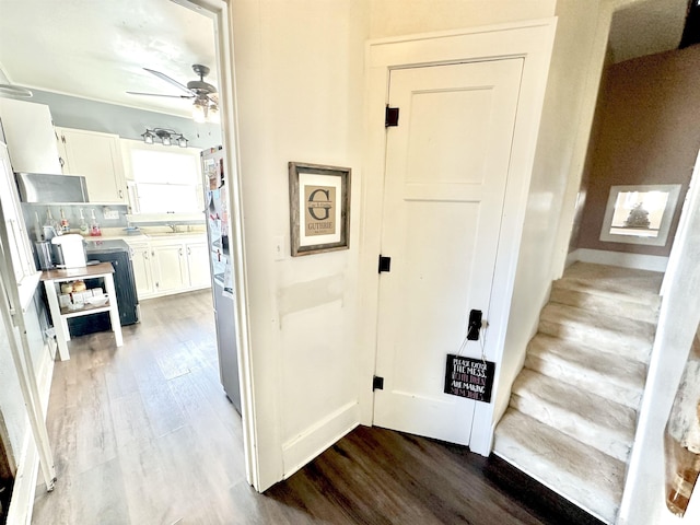 corridor with hardwood / wood-style flooring and sink