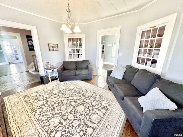 living room with wood-type flooring, crown molding, and a notable chandelier