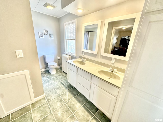 bathroom featuring radiator heating unit, vanity, and toilet