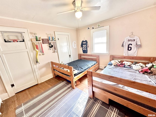 bedroom featuring crown molding, dark hardwood / wood-style flooring, and ceiling fan