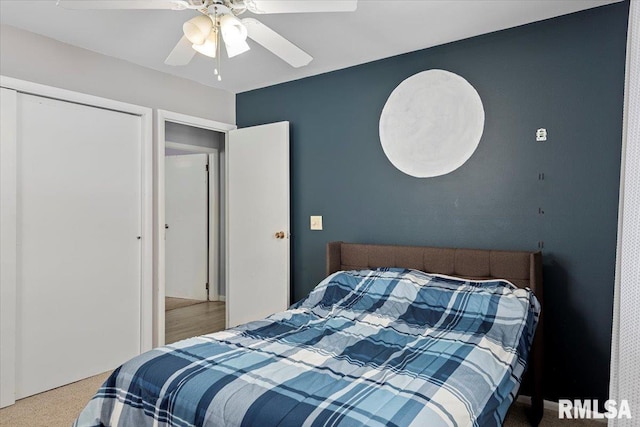 carpeted bedroom featuring ceiling fan and a closet