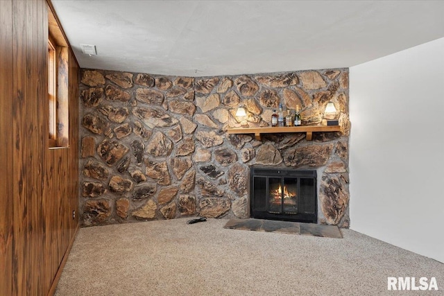 interior details featuring a fireplace, carpet floors, and wood walls