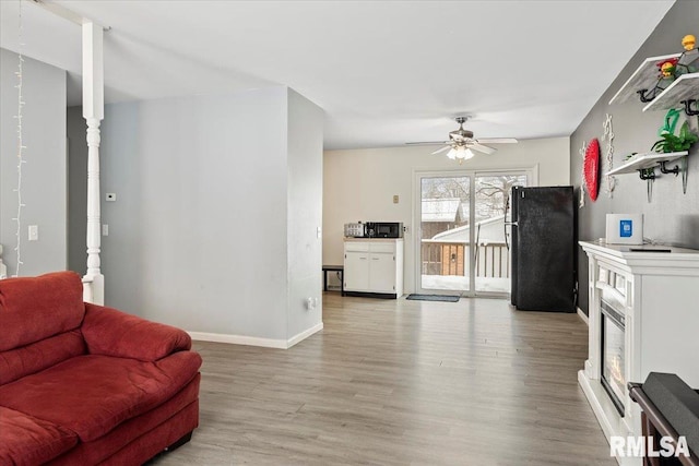 living room featuring ceiling fan and light hardwood / wood-style flooring