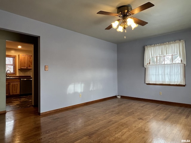 unfurnished room with dark hardwood / wood-style floors, ceiling fan, and sink