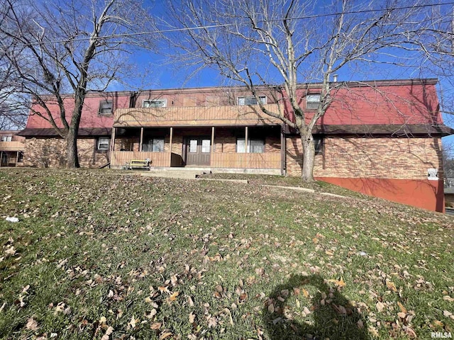 rear view of house featuring a patio area and a lawn