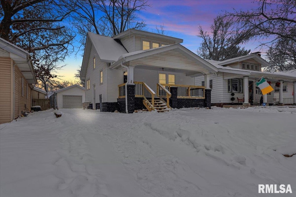 view of front of property with a porch, a garage, and an outdoor structure