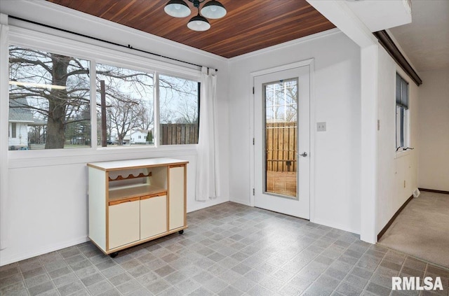 interior space with wooden ceiling, a healthy amount of sunlight, and crown molding