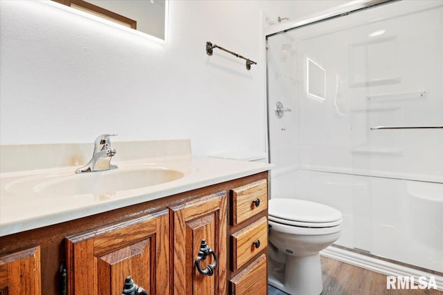 bathroom with toilet, vanity, an enclosed shower, and hardwood / wood-style flooring