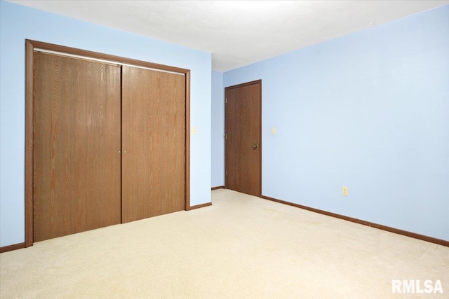 unfurnished bedroom with light carpet and a closet