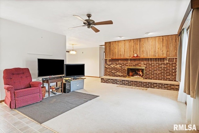 living room with ceiling fan, light colored carpet, a brick fireplace, and wood walls