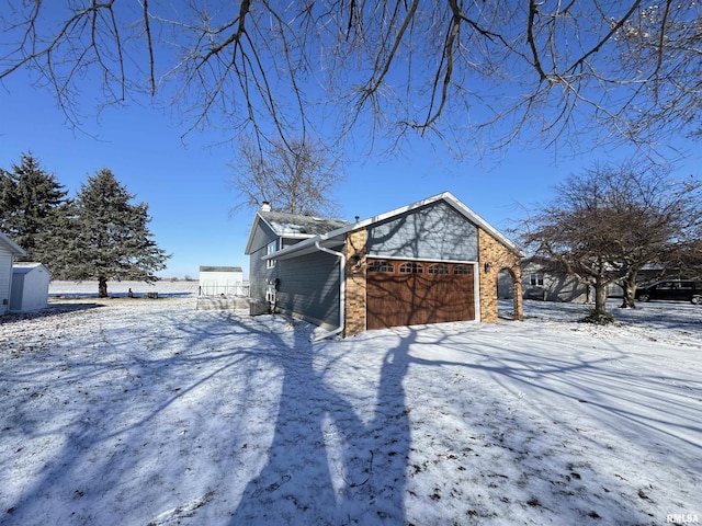 snow covered property with a garage