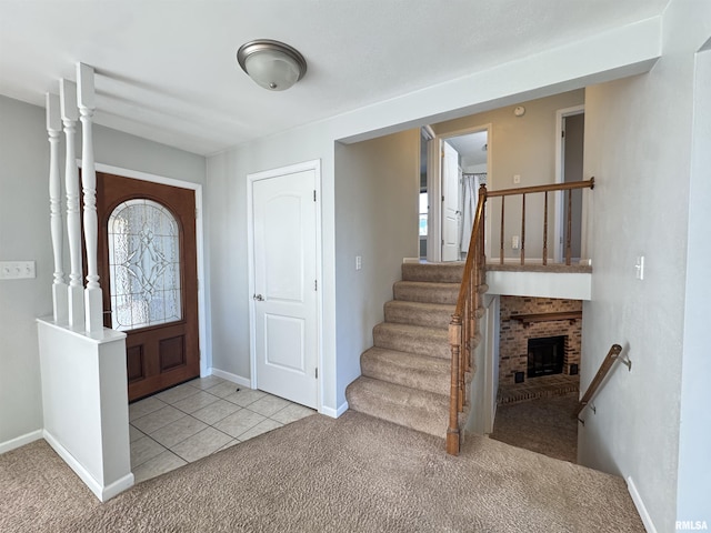 foyer entrance featuring a brick fireplace and light colored carpet