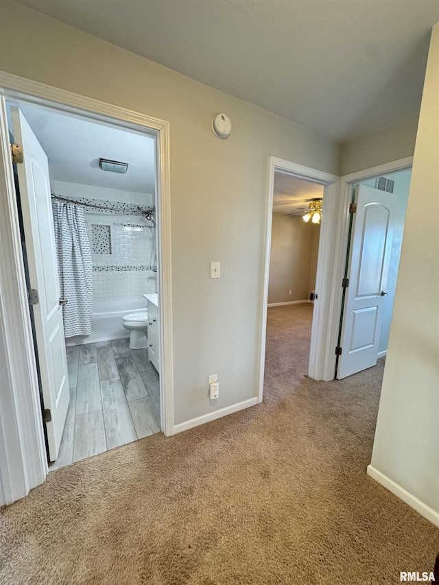 corridor featuring light colored carpet