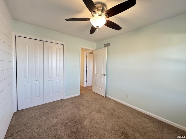 unfurnished bedroom featuring ceiling fan, a closet, and carpet flooring