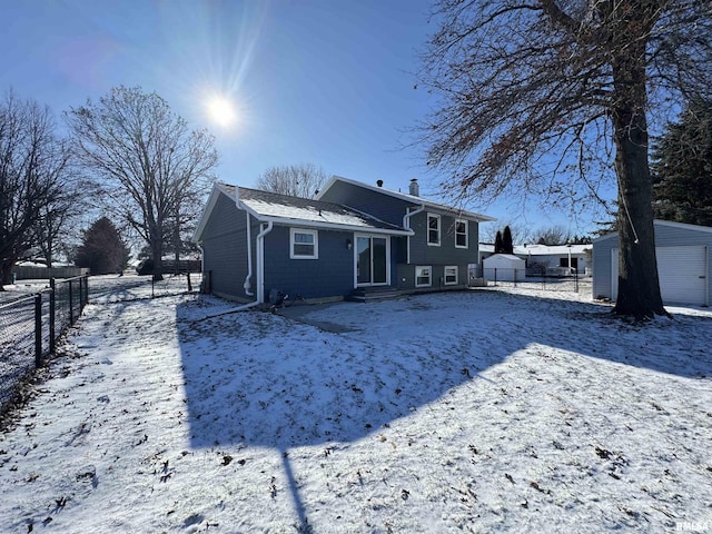 snow covered house with an outbuilding