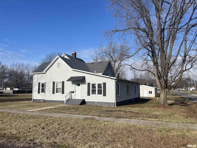 view of side of property with roof with shingles, a lawn, and a chimney