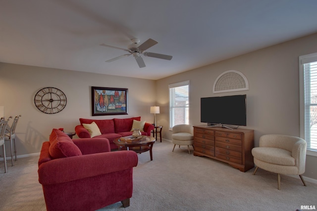 living room with a wealth of natural light, ceiling fan, and light colored carpet