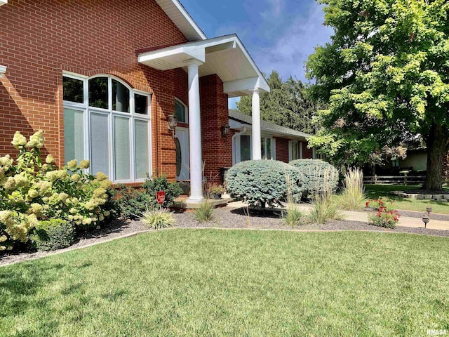 view of home's exterior featuring a yard and brick siding