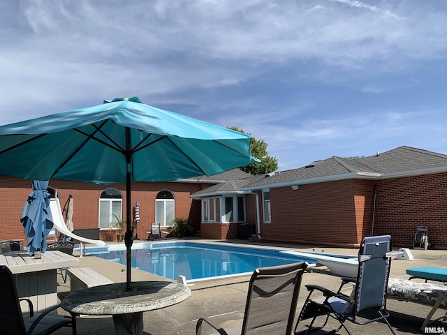 outdoor pool featuring a patio area and a water slide