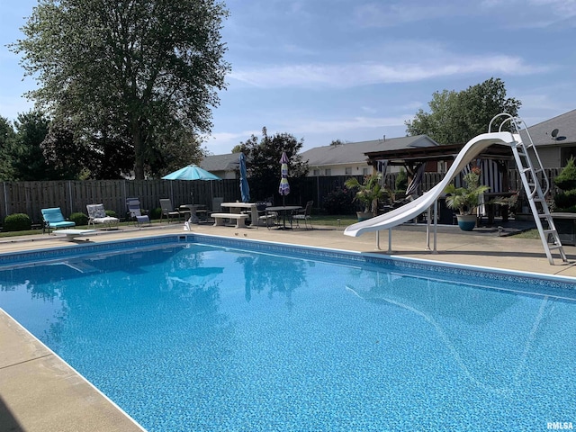 view of swimming pool with a fenced in pool, a patio area, a water slide, and a fenced backyard