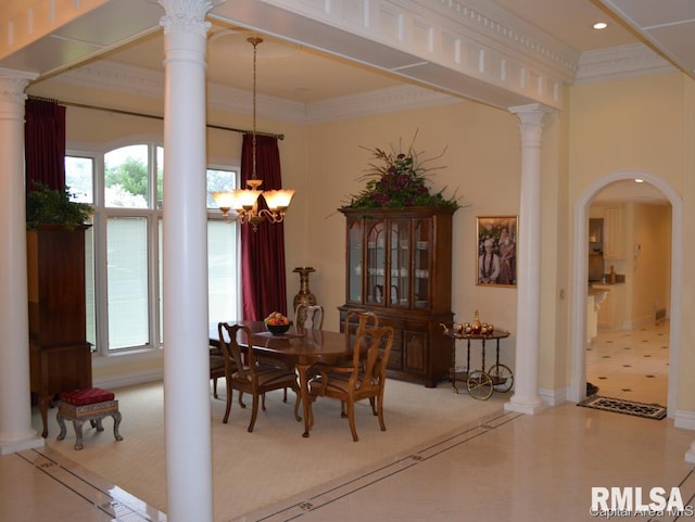 dining room with crown molding, a healthy amount of sunlight, and decorative columns