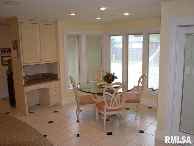 dining room with light tile patterned floors, baseboards, built in study area, and recessed lighting