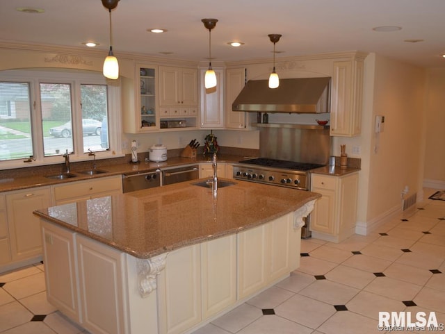 kitchen with dishwasher, a sink, under cabinet range hood, and dark stone countertops