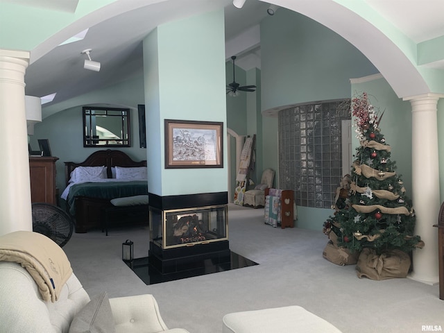 bedroom featuring vaulted ceiling, arched walkways, carpet flooring, and ornate columns