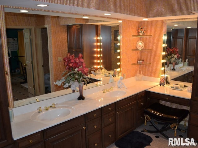 full bathroom featuring double vanity, a sink, and wallpapered walls