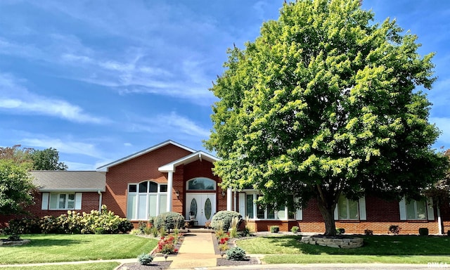 view of front of property featuring brick siding and a front lawn