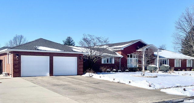 ranch-style house featuring driveway, an attached garage, and brick siding