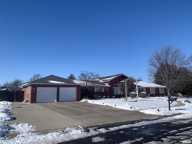 view of front of home featuring a garage, concrete driveway, brick siding, and fence