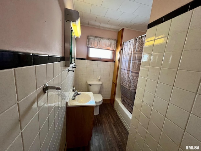 full bathroom featuring shower / bath combination with curtain, toilet, vanity, tile walls, and hardwood / wood-style flooring