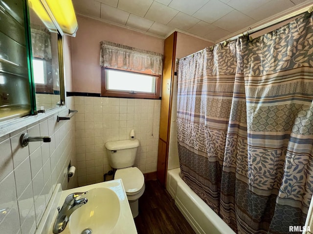 full bathroom with shower / bathtub combination with curtain, hardwood / wood-style floors, toilet, tile walls, and sink