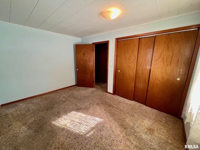 unfurnished bedroom featuring carpet flooring and a closet