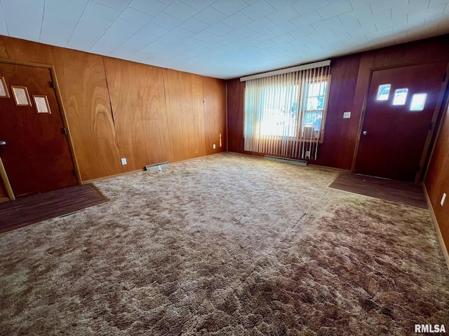 entryway with wooden walls and carpet floors