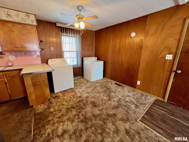 laundry room featuring cabinets, washing machine and dryer, carpet floors, ceiling fan, and wooden walls