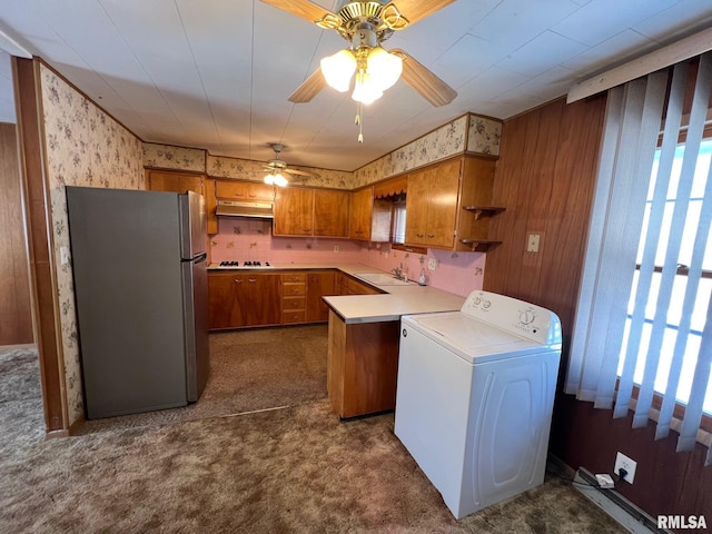 kitchen with washer / clothes dryer, dark colored carpet, stainless steel refrigerator, black electric cooktop, and sink