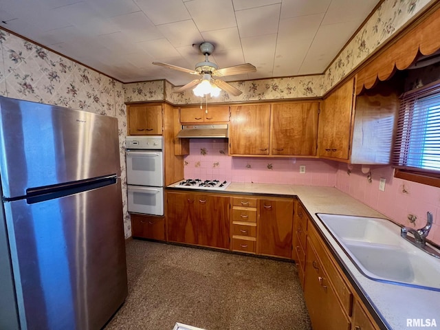 kitchen with white appliances, tasteful backsplash, sink, and ceiling fan