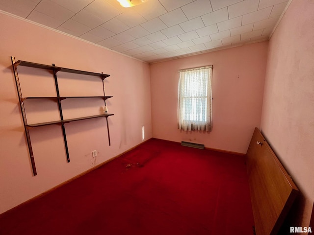 spare room featuring crown molding and carpet flooring