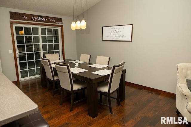 dining space with a textured ceiling, vaulted ceiling, and dark hardwood / wood-style flooring