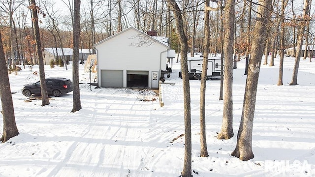 yard covered in snow featuring a garage