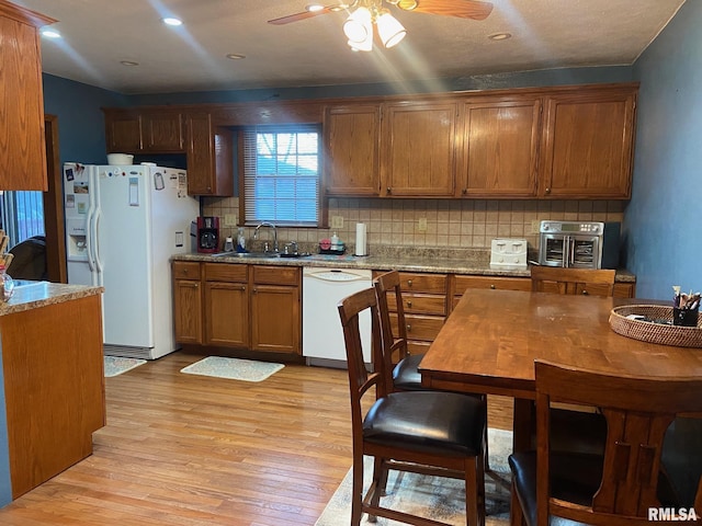 kitchen with ceiling fan, tasteful backsplash, sink, white appliances, and light hardwood / wood-style flooring