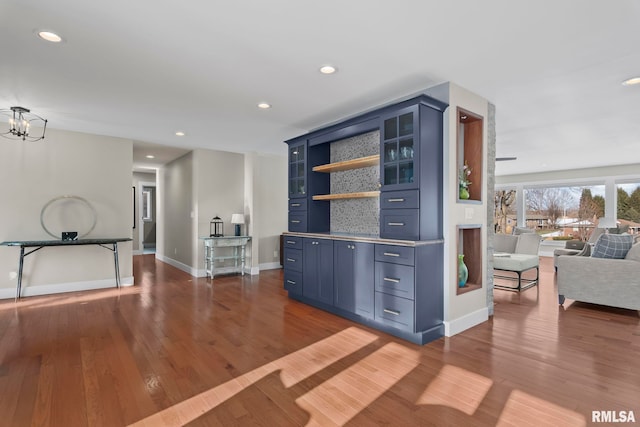 bar with an inviting chandelier, hardwood / wood-style floors, and blue cabinets