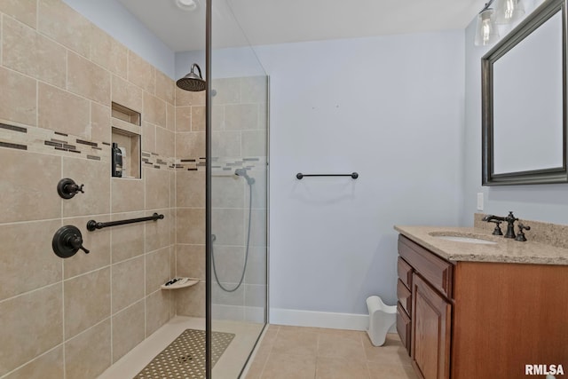 bathroom featuring vanity, tile patterned flooring, and a tile shower