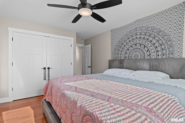 bedroom featuring light hardwood / wood-style flooring, a closet, and ceiling fan