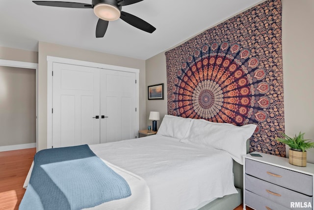 bedroom featuring hardwood / wood-style flooring, ceiling fan, and a closet